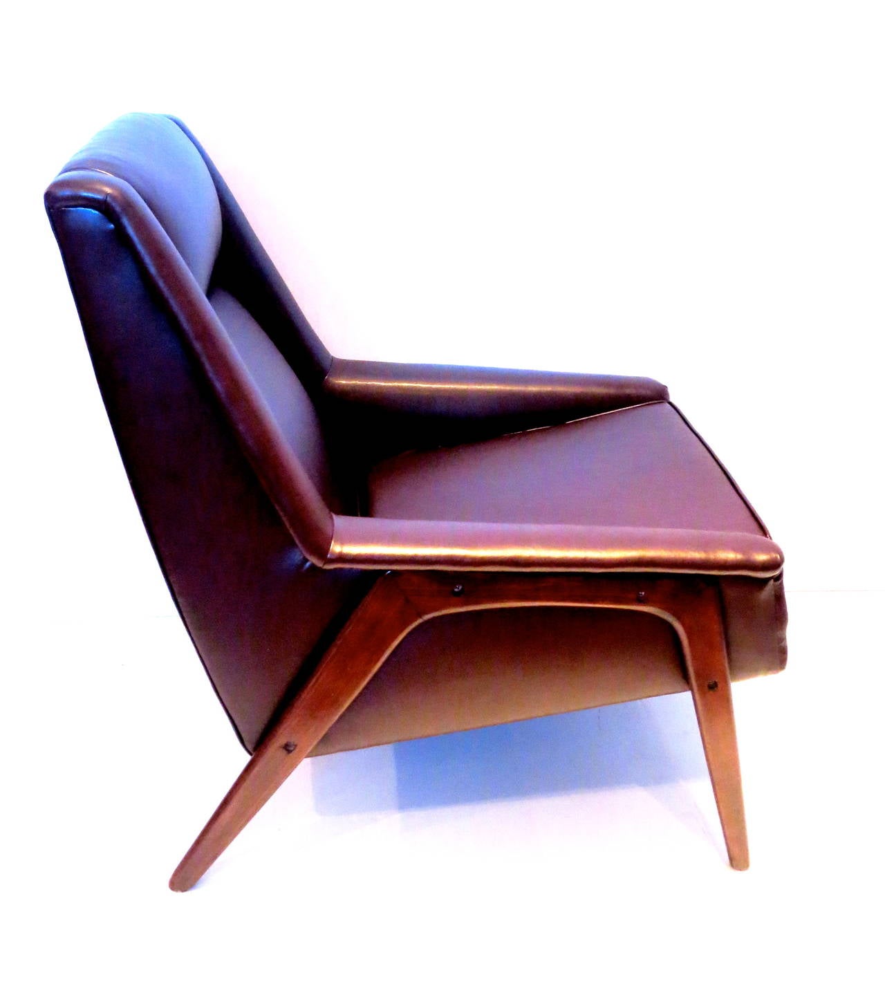 Striking chocolate brown arm chair designed by Folke Ohlson, for DUX of Sweden the chair its completly restored , in leather the legs are refinished in walnut stain the chair its solid sturdy and comfy .