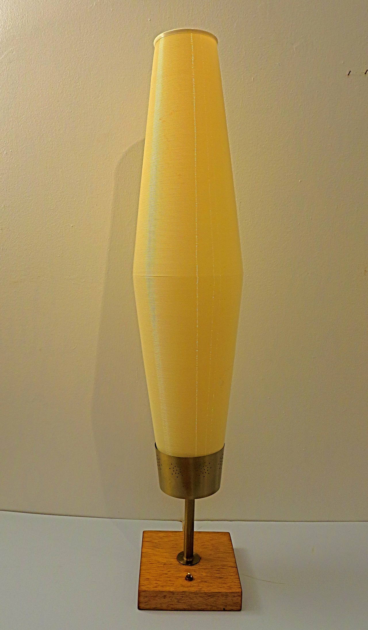 Striking tall and rare lamp designed by Heifetz with a plastic corrugated shade by Rotoflex, circa 1960s great condition push off/on switch, the wood base its refinished and perforated brass stand.