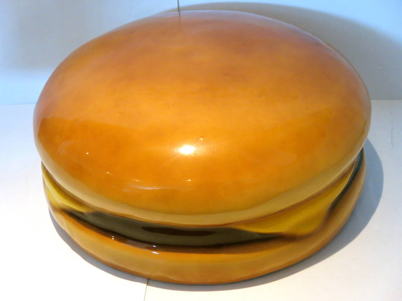 A very unique giant cheese burger , circa 1980s made of molded foam covered with a clear glossy resin , can be used indoors or outdoors , as a chair , ottoman or hang on the wall its heavy , truely a conversation piece , nice condition light wear.