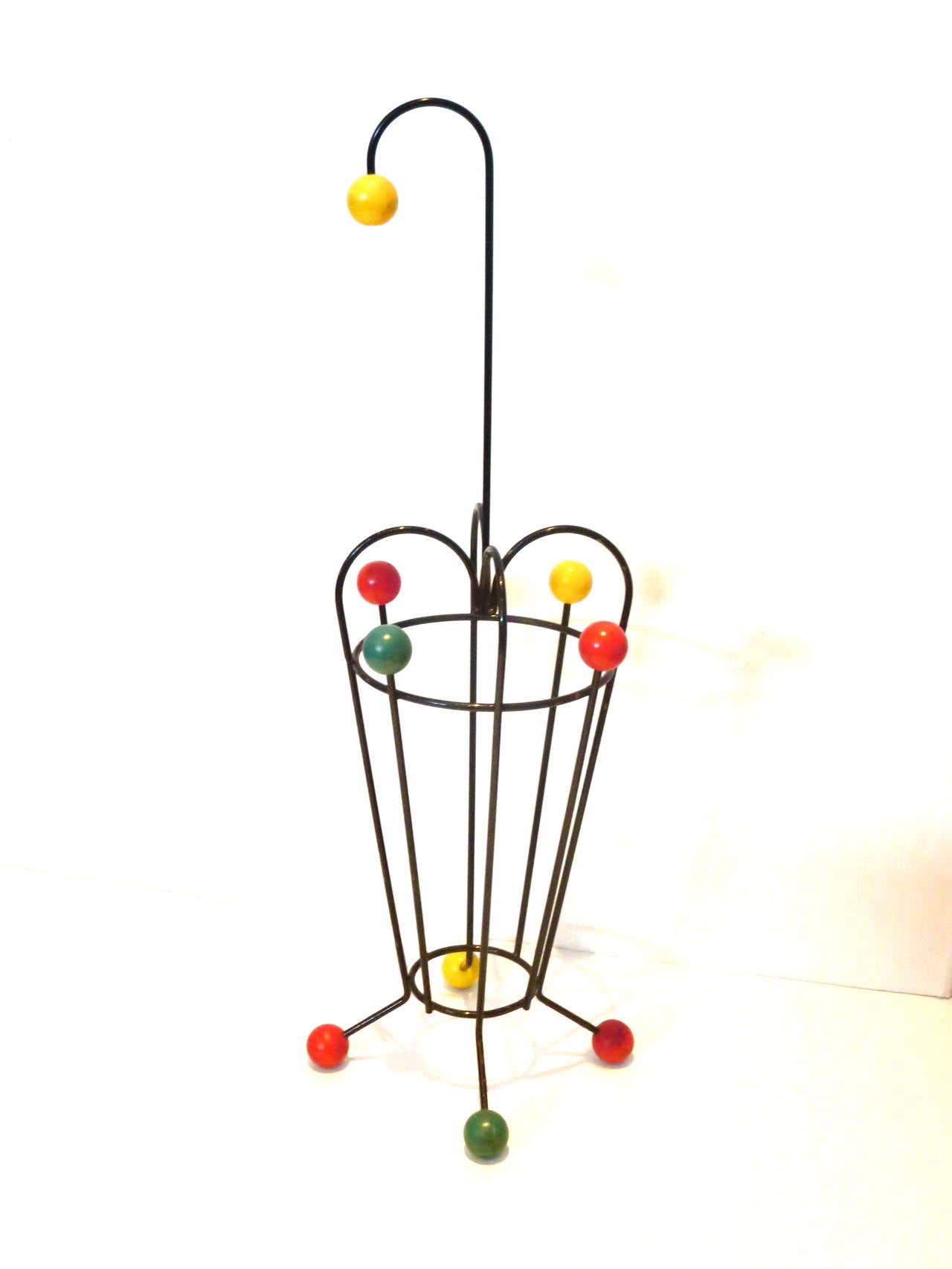 A very cool and unique umbrella stand, circa 1950s made in France iron and color painted decorative wood balls, nice original condition a beautiful piece of art.