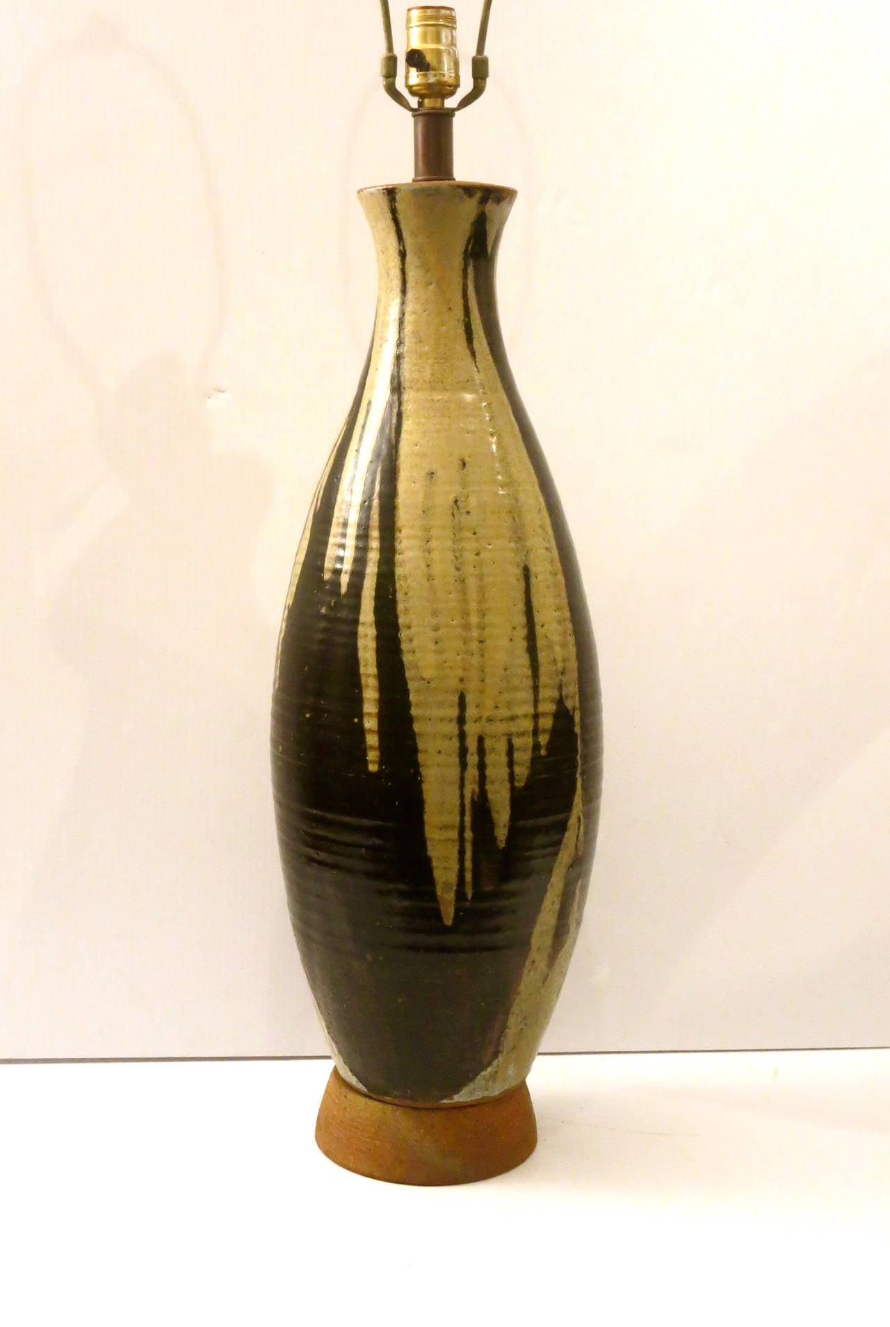 Striking tall table pottery lamp by famous San Diego potter, Wayne Chapman beautiful glaze colors and shape, even the bottom base its made of pottery, label and his signature are impress on the base. Excellent condition no chips or cracks, and