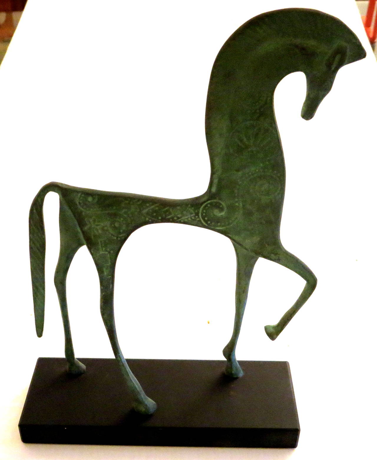 Elegant and refine lines on this stylized Etruscan horse , in patinated bronze finish sitting on a solid black slate base, circa 1960s. unsigned.