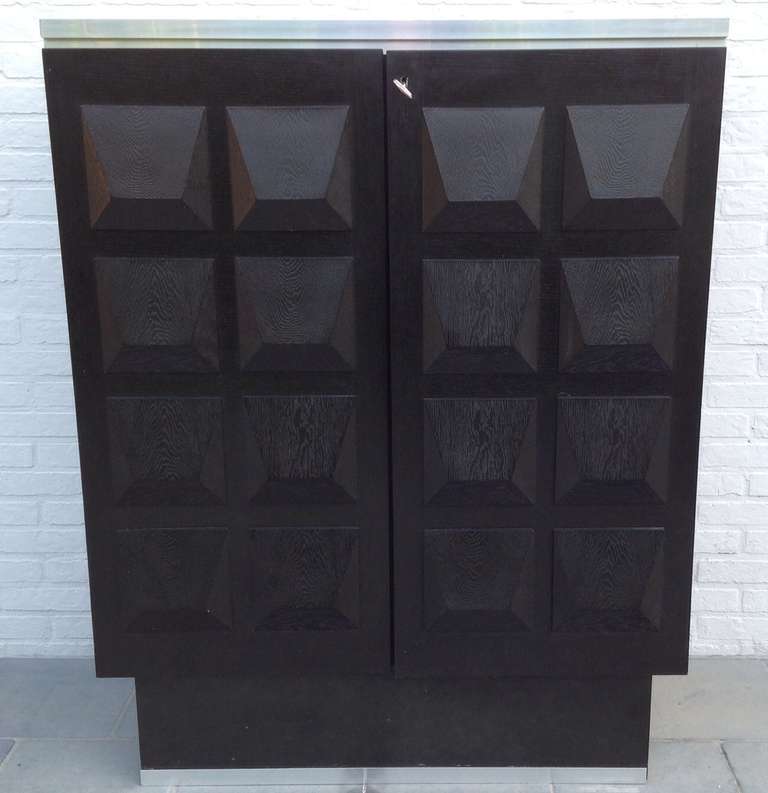 Very decorative graphic highboard with black oak surface sculptural shapes and aluminium details.
The detailed pattern gives this highboard it's unique expression.