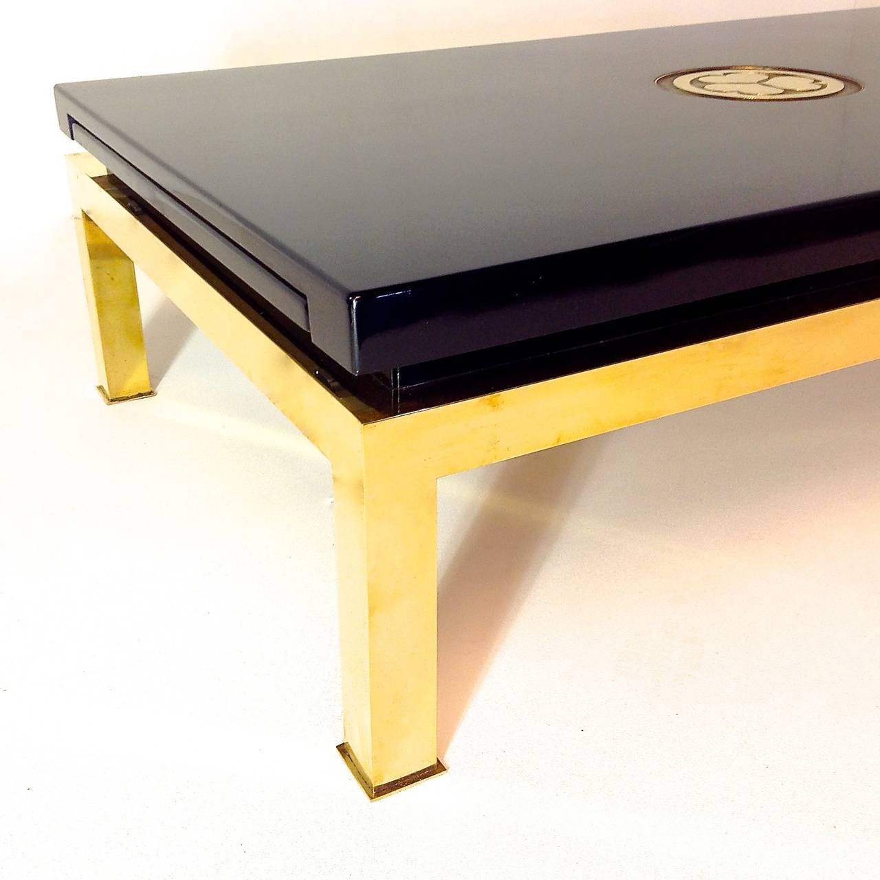 Very exclusive and elegant coffee table, by Tommaso Barbi.
Special offer, this furniture are manufactured in a small quantity.
Polished brass base with deep black lacquered wood.
Brass plate insert in the tabletop, inspired by Japanese mon, could