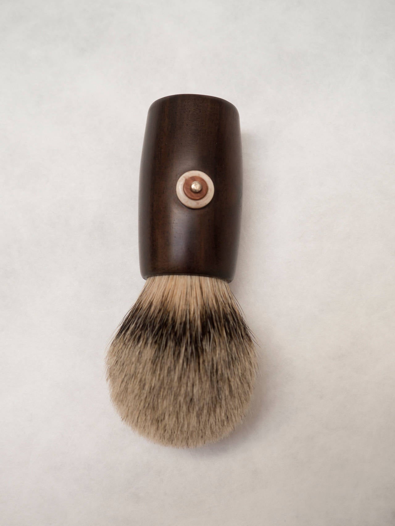 Men's shaving brush made of badger hair and wood with silver and bone detail.