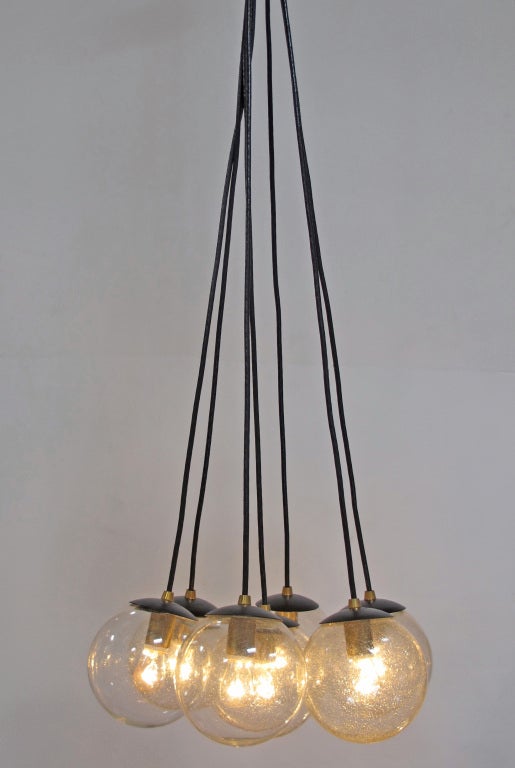 Striking chandelier designed with 7 pieces of round vintage crackle glass in perfect condition. Made with new black and brass parts. One medium base bulb per piece of glass. 
Overall height is 72