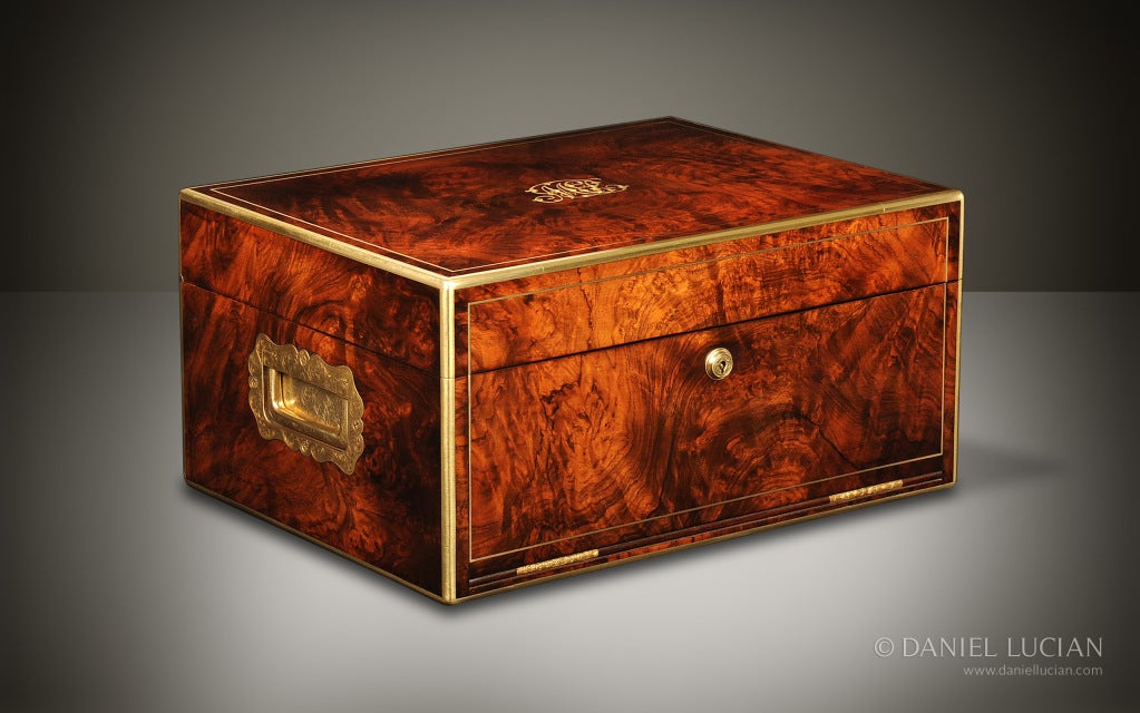 This magnificent large jewelry box, dating from around 1850, is veneered in figured Walnut, and is edged in brass with brass stringing inlay. The box is embellished with large side handles, beautifully engraved, and an elaborate central monogram on