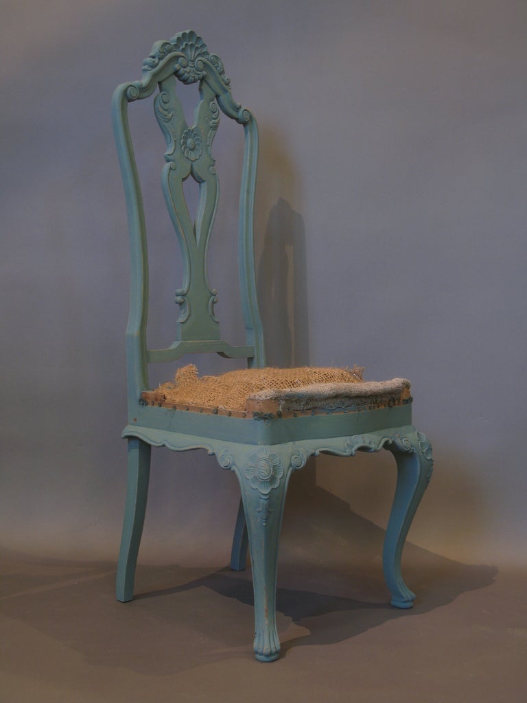Six ornately carved baroque/rococo style chairs with high, slightly curved backs, carved with shell and rosette details on the central crest rails, back splats, knees and aprons. The front legs end in paw feet.

The seats are currently not