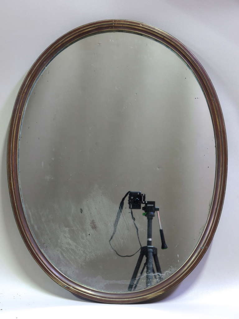 Understated and elegant antique oval mirror with a copper (or bronze?) frame. Very heavy and well-made.