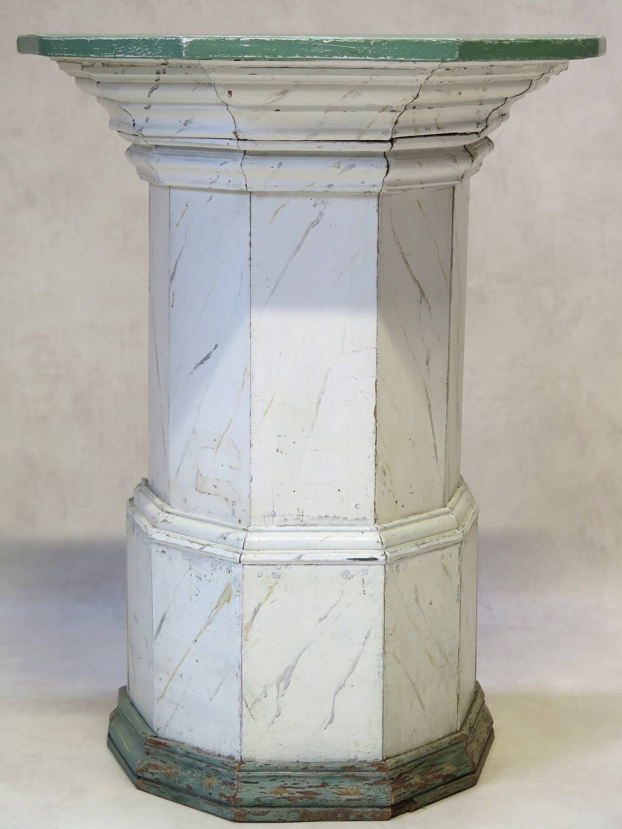 Unusual faceted wooden column or pedestal, painted in off-white trompe-l'oeil of Carrara marble, with a verdigris plinth, and light green top.