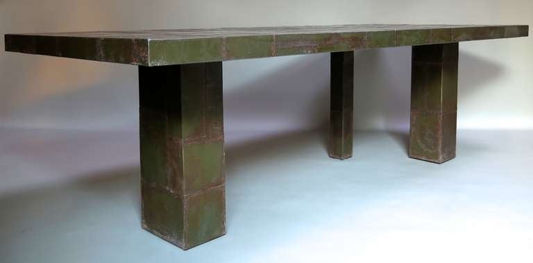 A striking long rectangular table entirely clad in a patchwork of vintage sheet metal with original green patina. Supported by three square legs of different sizes.

Unique design by Xavier Nicod. The last available of three.