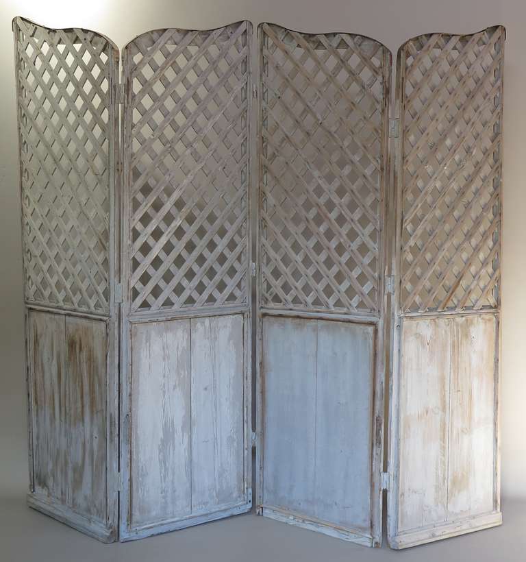 Charming folding screen with four panels, the top part trellised. Light blue-gray patina.

Dimensions provided below are per panel (i.e. folded).