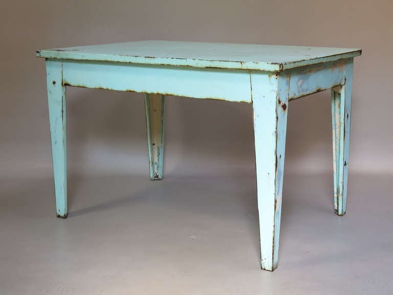 Rectangular dining table made of bent/folded sheet metal, painted blue/green, with traces of rust & white showing through. Tapering legs.

Also available are two similar tables with a different finish (iron, with traces of off-white paint).