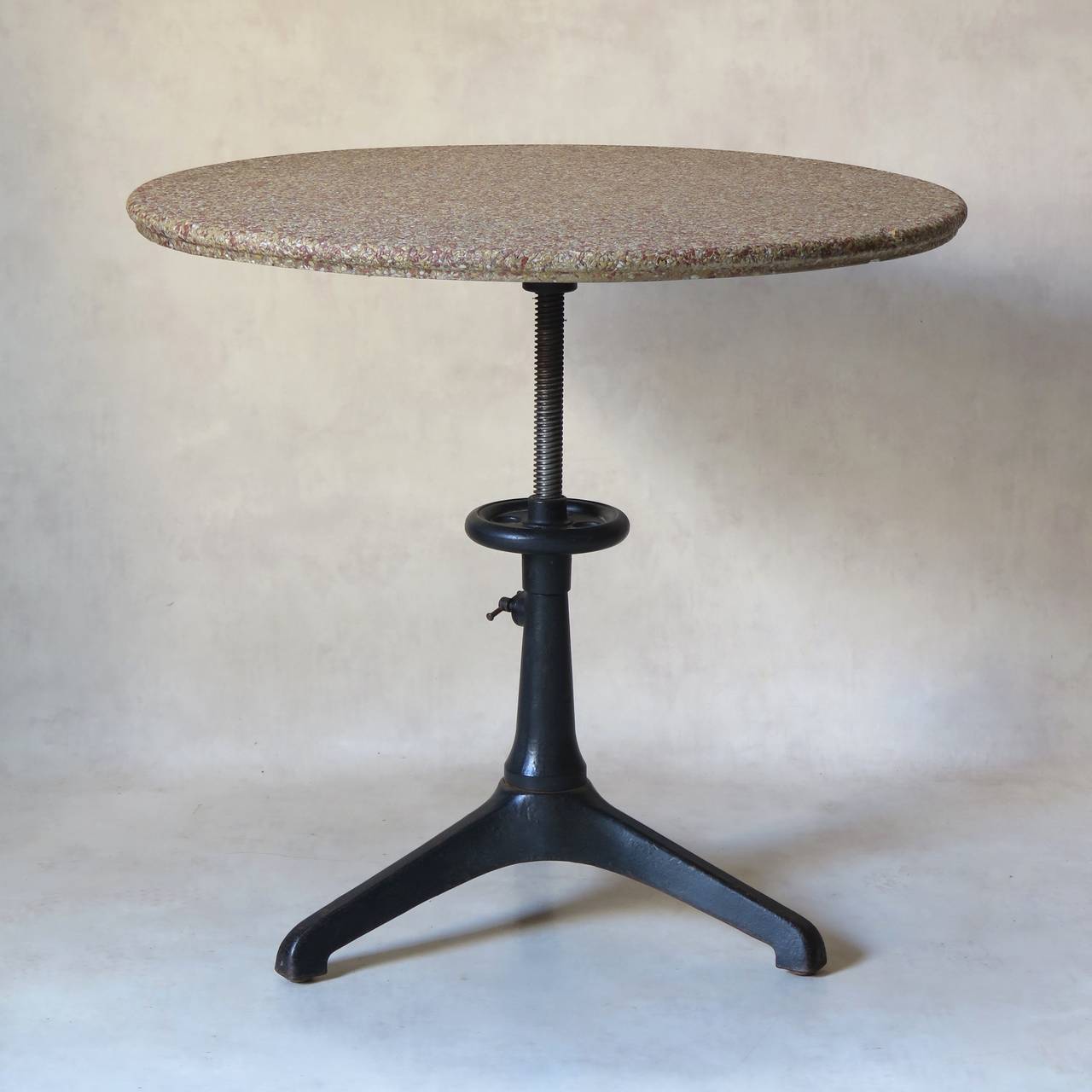 Nicely designed cast iron Industrial tripod table. The height is adjustable. Round pinky-grey terrazzo table top.

Dimensions provided below correspond to the lowest table height possible. Fully extended, the height is 83 centimeters (32.67