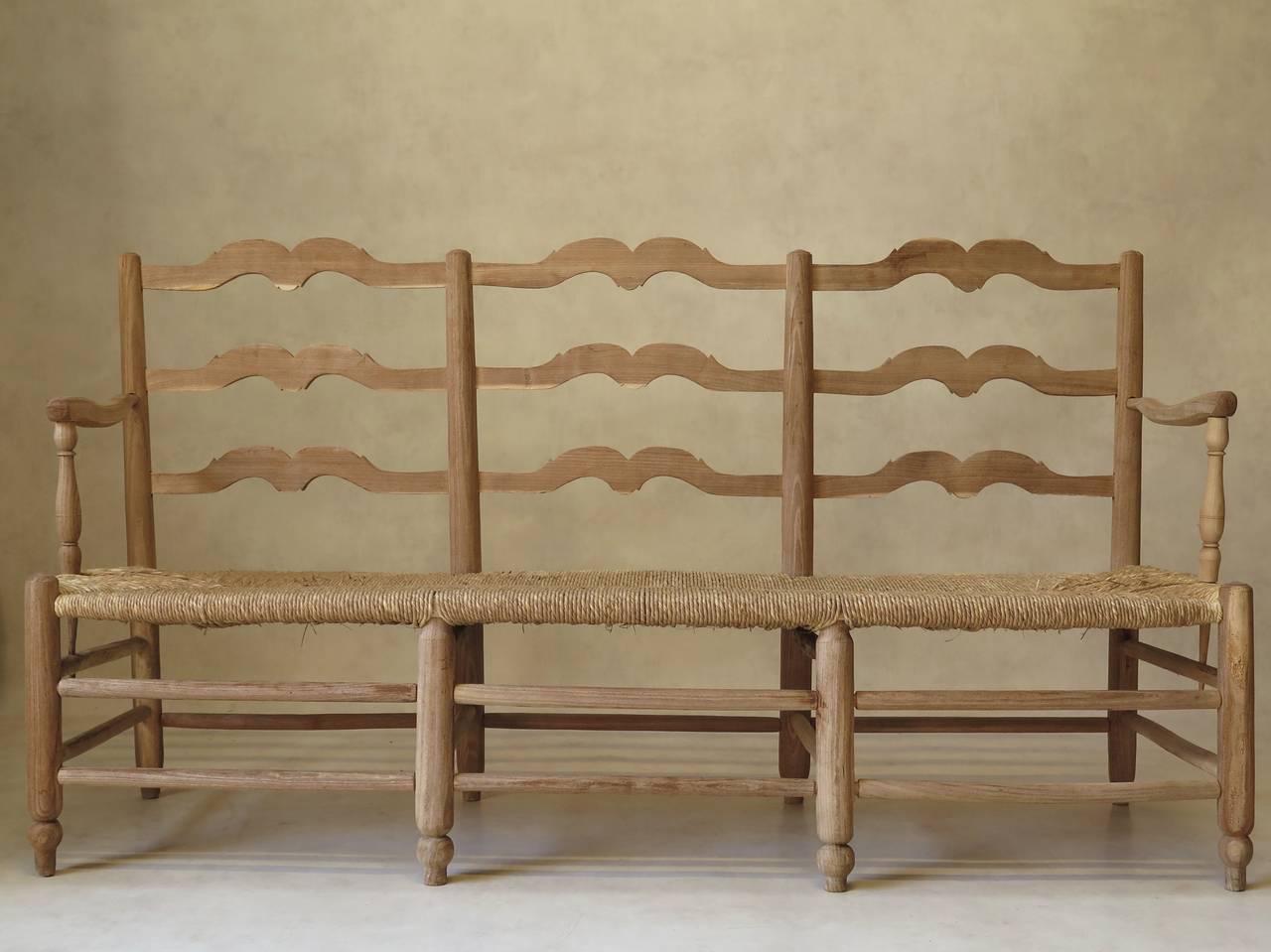 French wood and rush bench or settee (aka radassier) from Provence. Stripped, light-colored wood. Elegant, rustic charm.