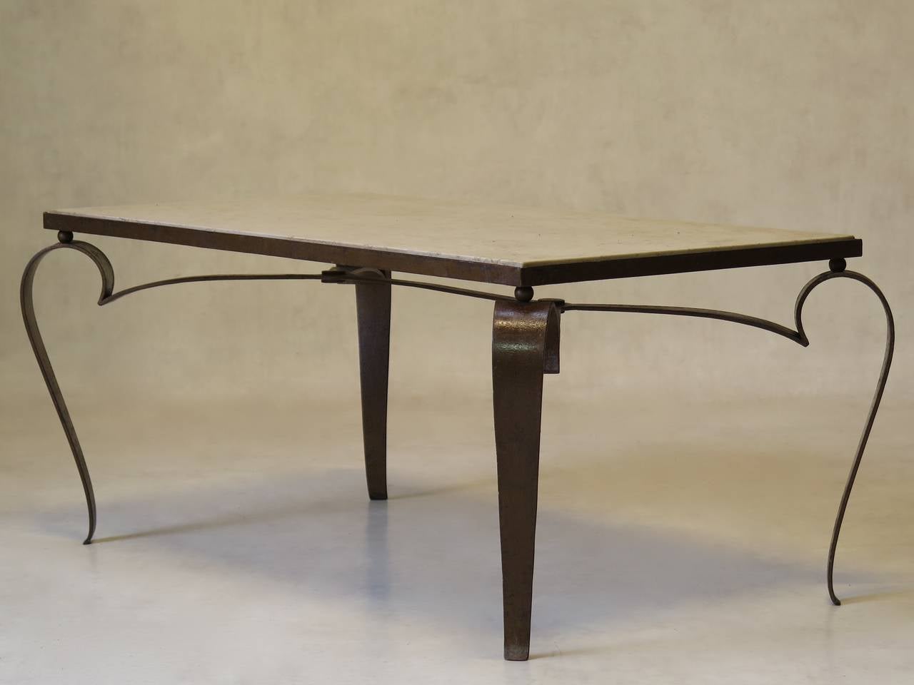 Encantadora mesa de centro rectangular con base de hierro dorado y tablero de piedra beige.