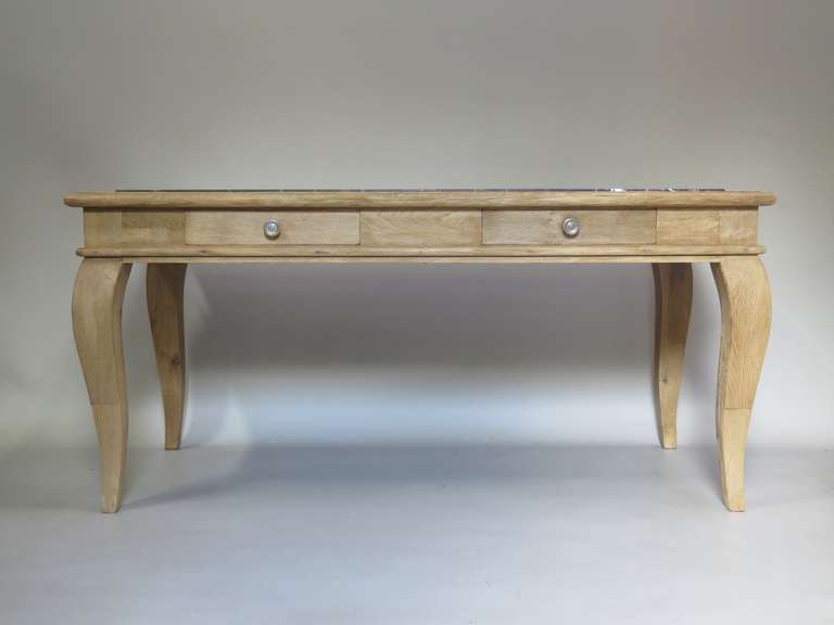 Lovely console or desk of brushed oak, with a slightly raised marble top framed by an oak surround. Elegant lines. Raised on generous cabriole legs. One side of the apron has a mustache shape; the other contains two drawers. The marble is matte