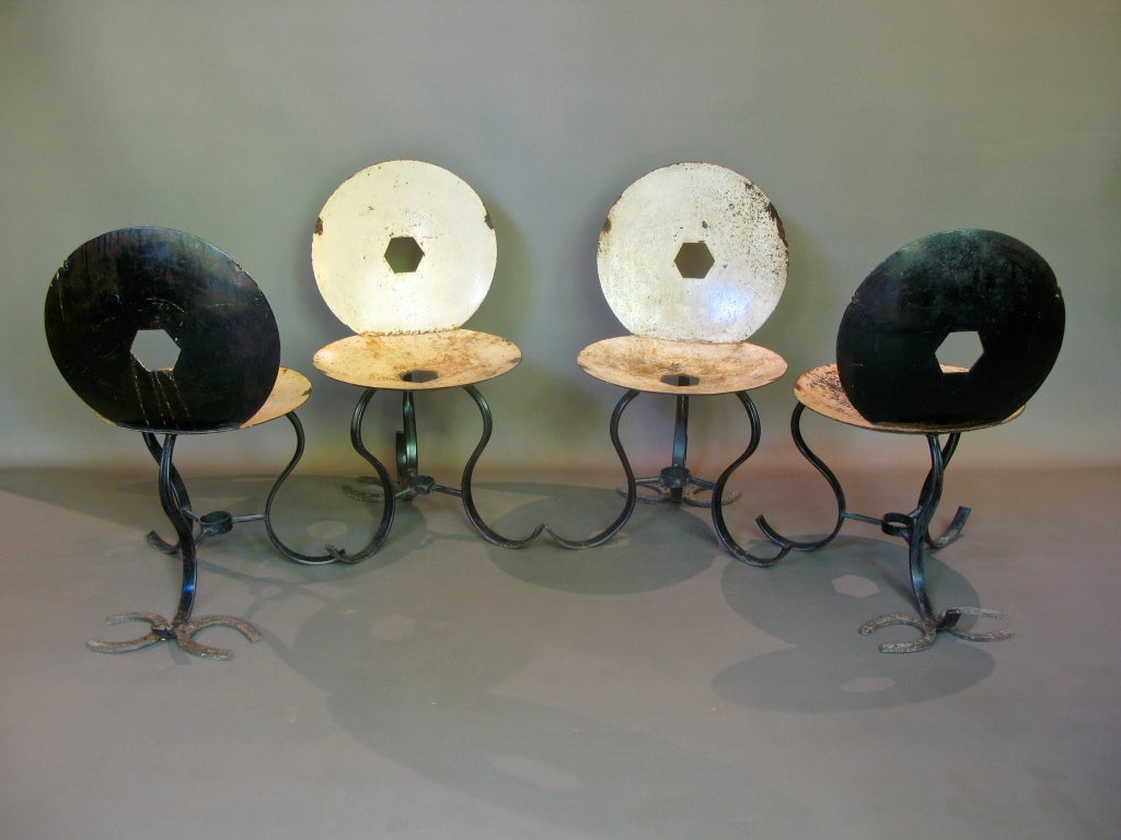 One-of-a-kind set of four chairs. The seats and backs are made from circular tractor pieces and a pair of horseshoes welded onto the rear foot of each chair adds stability as well as aesthetical value. The legs are made of S-shaped curved iron.