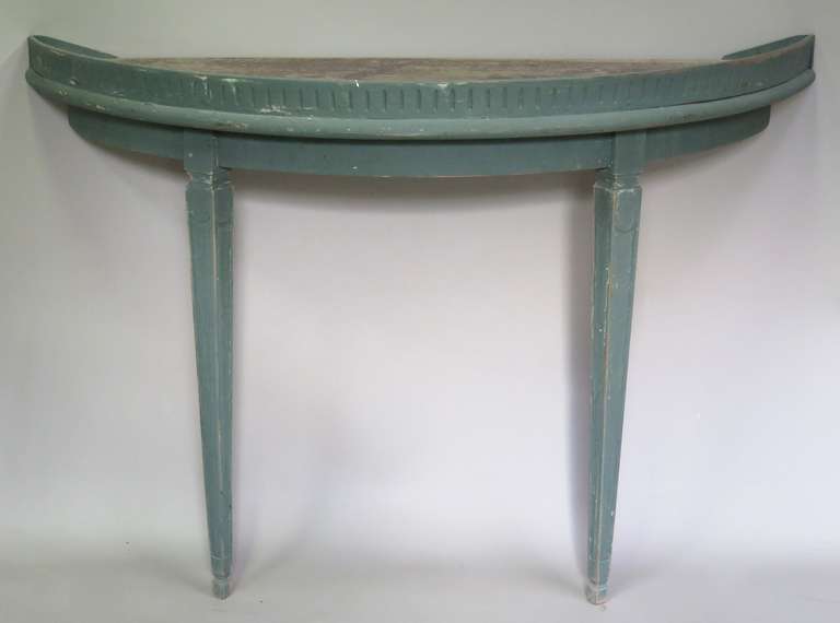 Elegant demi-lune console of Louis XVI style in a light grey-green, with tapering legs and a reeded front. The top is bears its original worn patina.
