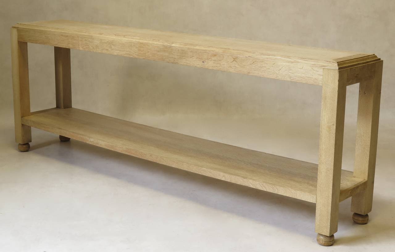 Long and slim console with two tiers, in light-colored brushed oak. Elegant, unfussy design.