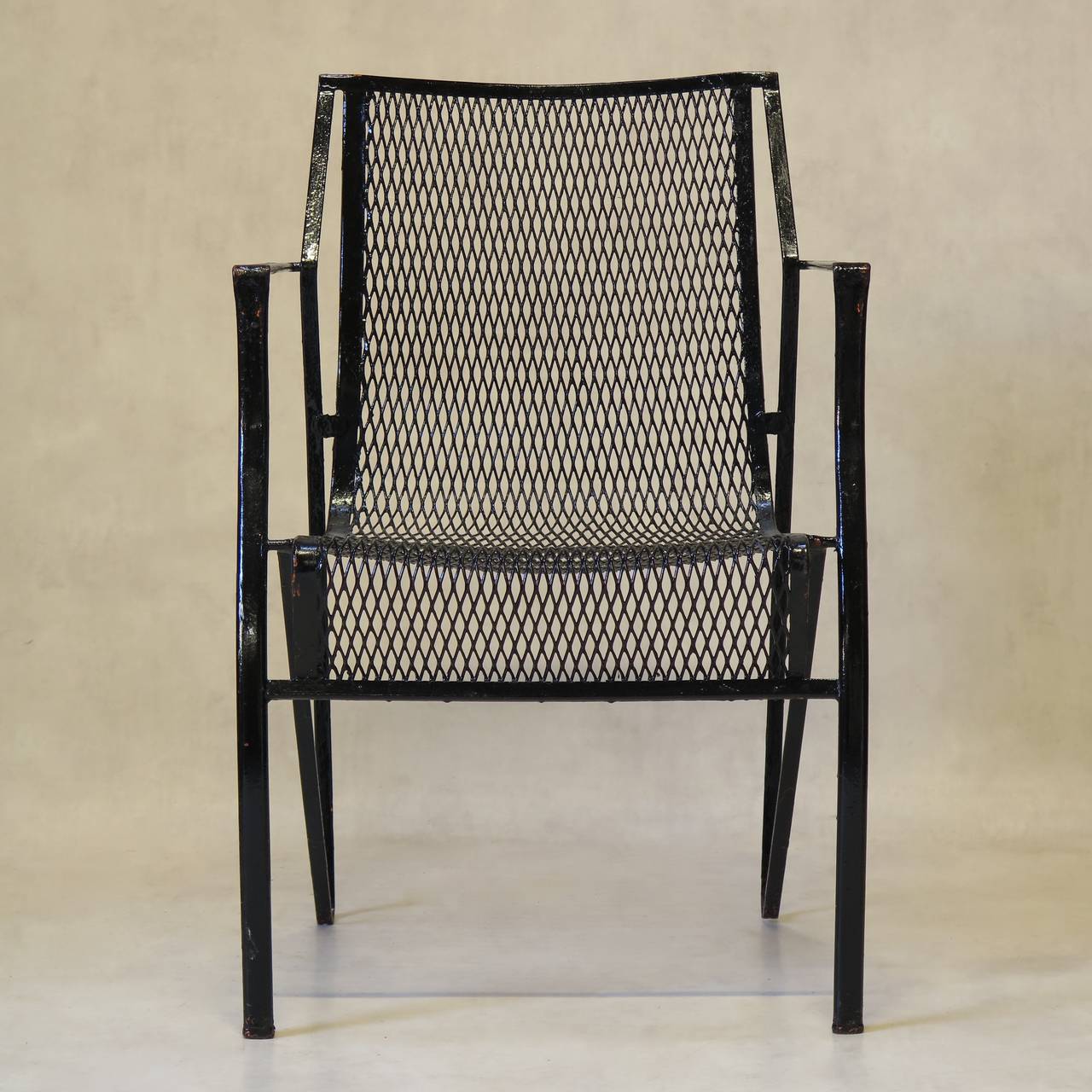 Set of ten armchairs made of iron with a glossy black finish. Nice lines. Traces of reddy-orange primer visible beneath.