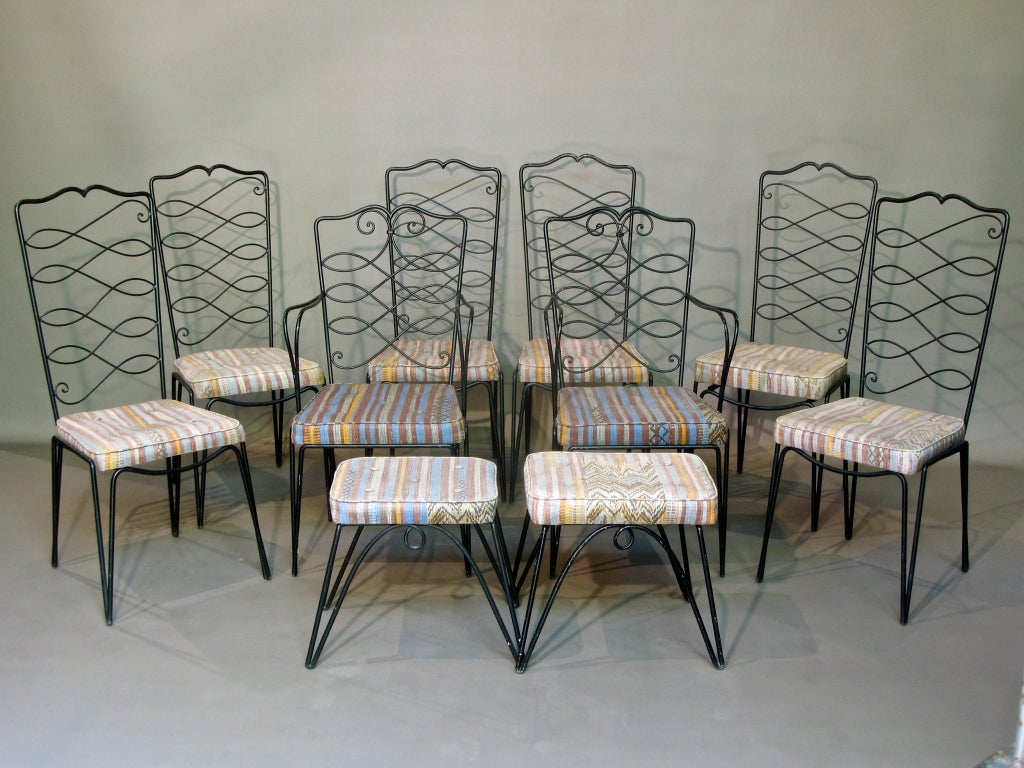 Wonderful French 1940s set of six chairs, two armchairs/chargers and two stools by René Drouet. The structure is of wrought iron, painted black, and the seats retain their colorful original cotton upholstery. High backs with a calligraphic