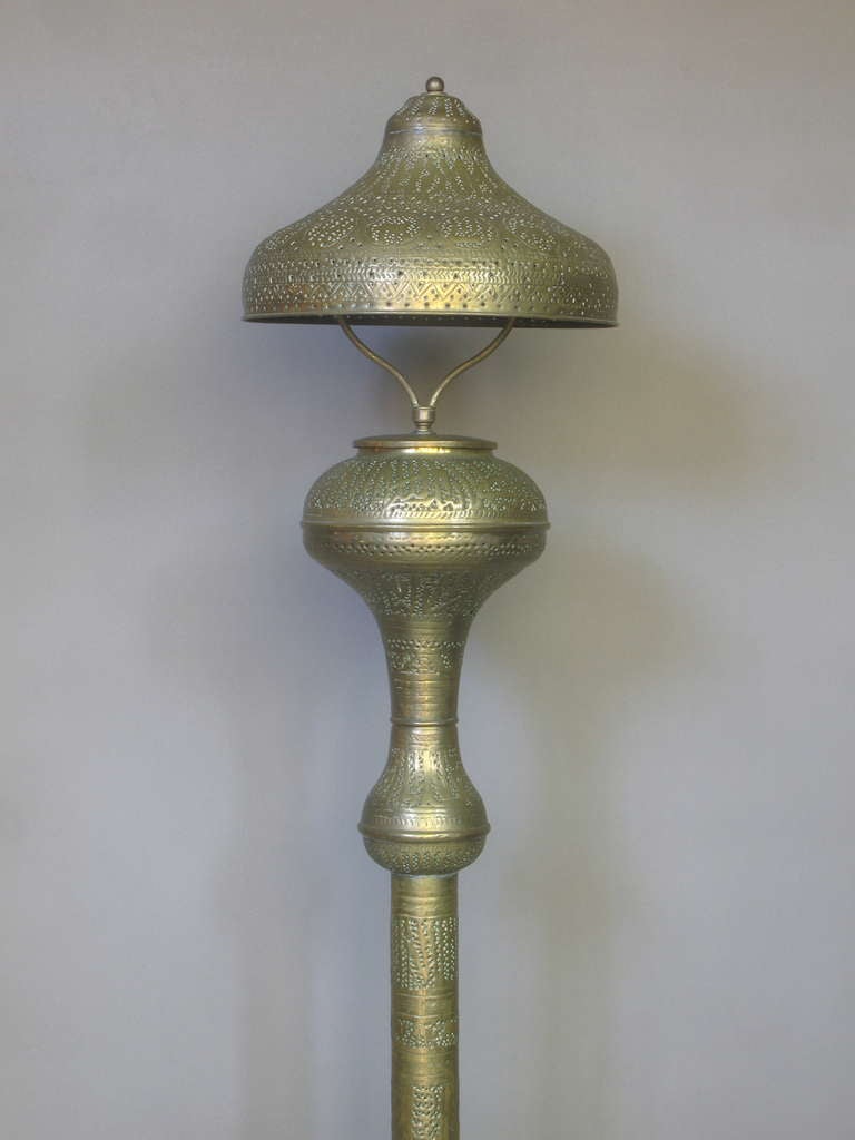Elegant floor lamp and lamp shade of brass decorated throughout with motifs made by etching and perforating the metal: arabic calligraphy, animals and various geometrical patterns.