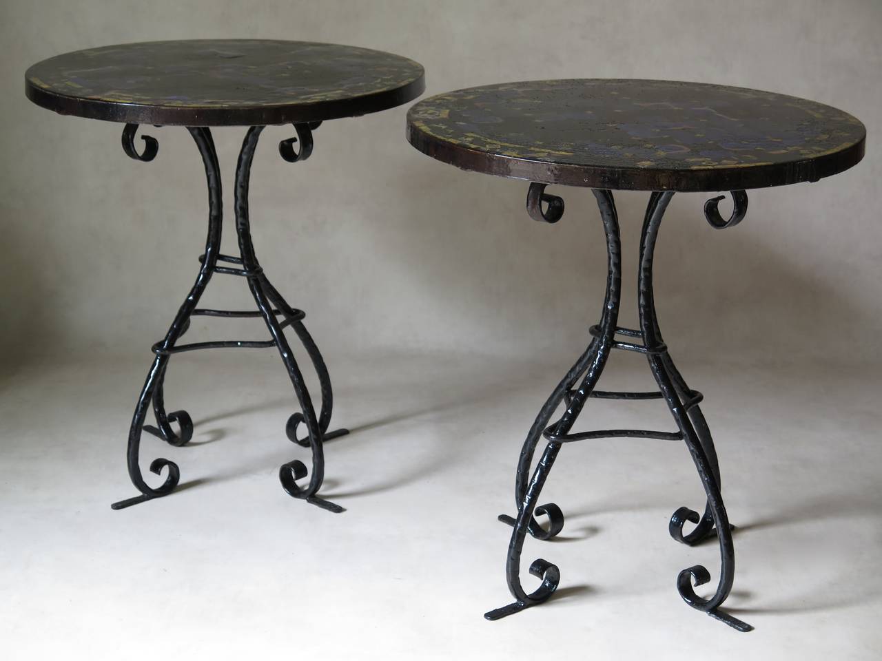 Very beautiful and rare pair of side tables with yellow and vivid blue mosaic tile tops and elegant sinuous wrought iron bases, with glossy blabk paint finish. Ironwork reminiscent of Gaudi's style.