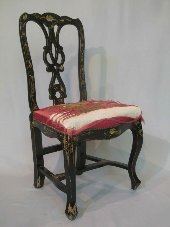 Exquisite pair of ebonized side chairs, hand-painted with a decor of birds, butterflies and foliage. 
Original deep pink satin seat covers, both intricately embroidered with peacock, birds, butterflies and bamboo.