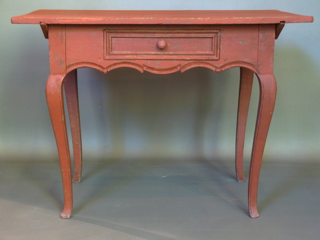 Charming carved table on cabriole legs, with central drawer.