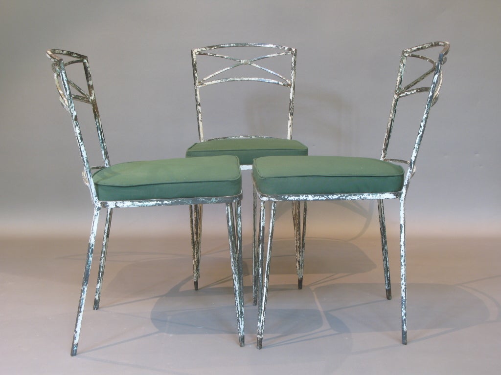 Set of three hand-wrought iron chairs of outstanding quality and design, in the style of Jean Royère, dating from the 1940s-1950s. 
Traces of original white paint.  
Newly reupholstered in hard wearing green canvas for use outdoors as well as in.