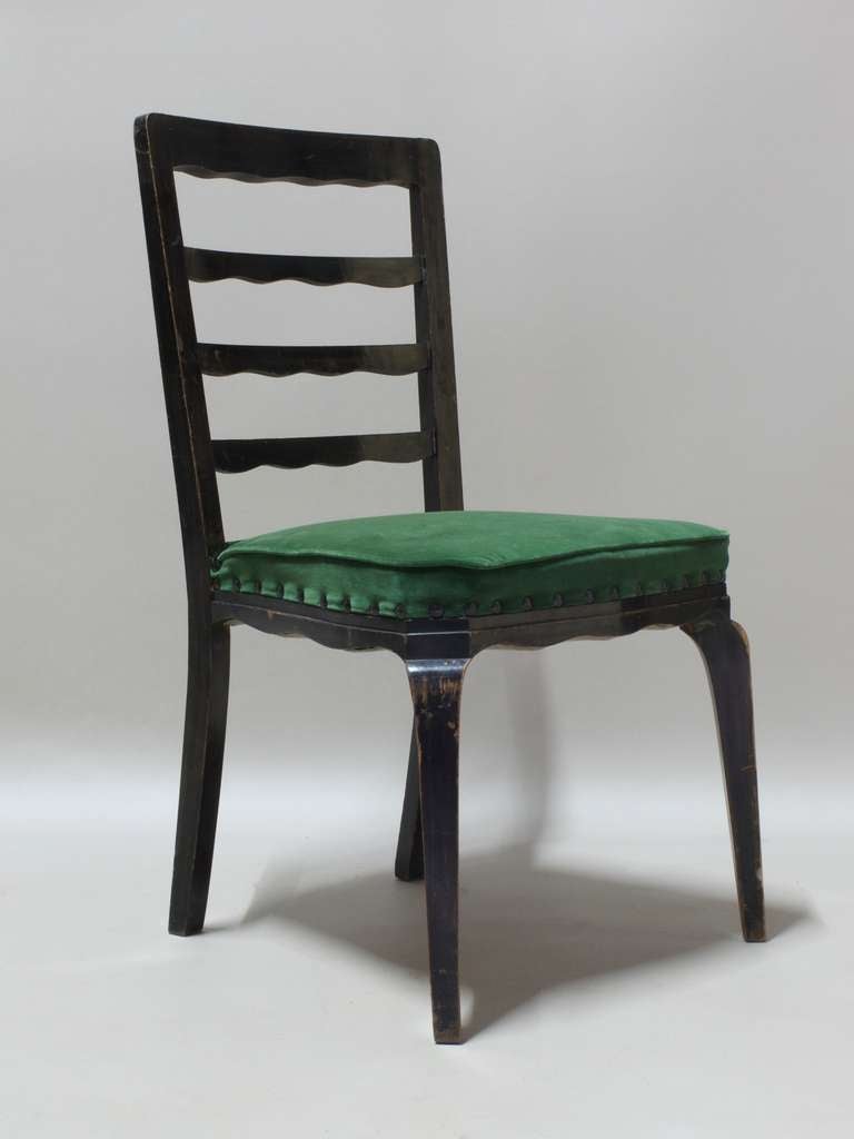 Six elegant chairs with wide and comfortable seats upholstered in emerald green velvet, with lovely wavy detailing on the backs and around the seats.

Sturdy and well-made.