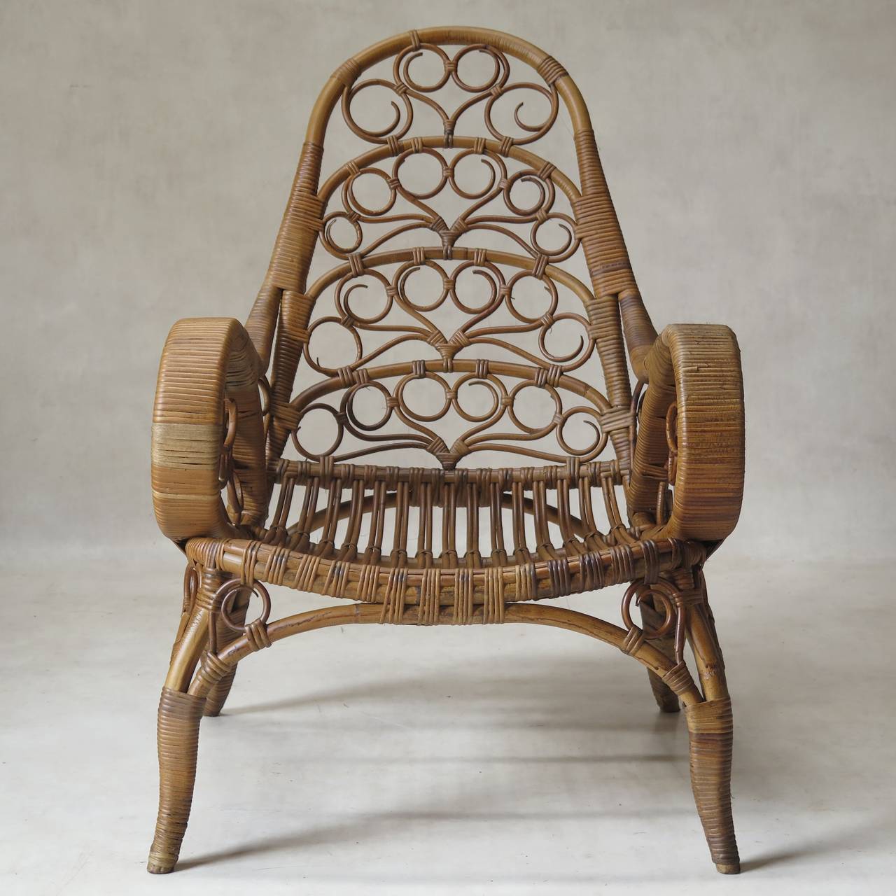 Lovely pair of low and wide wicker armchairs, in warm honey tones.