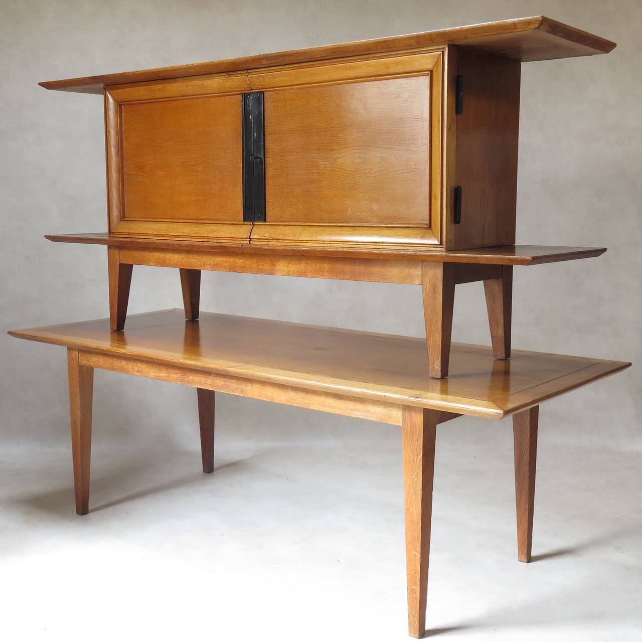 Beautiful, minimalist chic dining table and credenza set. The top of the table and credenza end in pagoda-style beveled edges. Tapered legs. Lovely warm colored oak.

Dimensions provided below are for the table. The sideboard measures (in