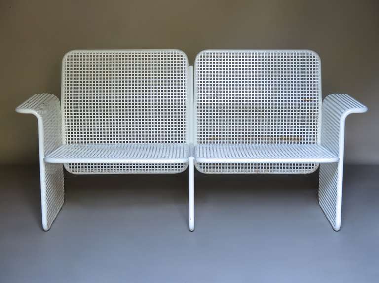Outdoor set of alluring geometric/cubist design, comprised of a settee/bench, two armchairs and a low table, in white-lacquered iron. Lightweight. Deep and comfortable seats.

Measurements provided below are for the settee. Each armchair measures