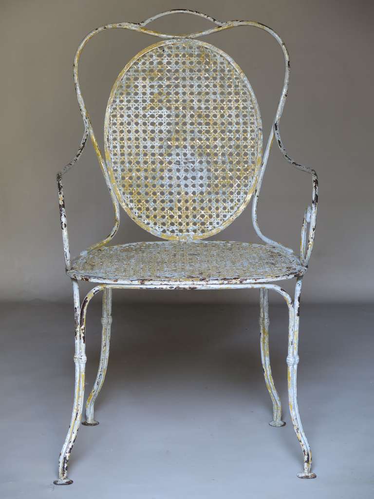 Un classico senza tempo, con deliziose sedute e schienali ovali in filo di ferro, braccioli a voluta ed eleganti gambe strombate. Patina originale: grigio chiaro con precedente vernice gialla visibile sotto.
Molto robusto e ben fatto.

Da usare
