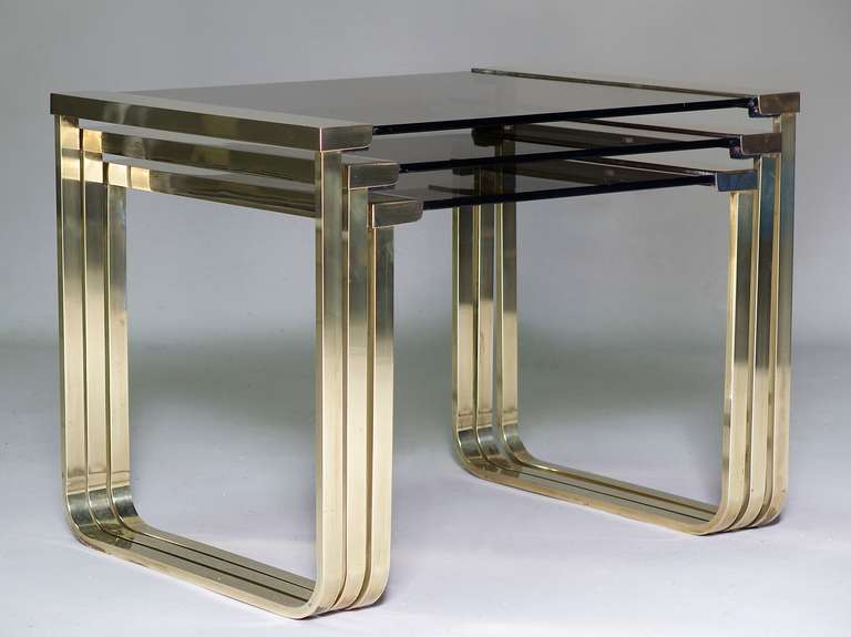 Chic and streamlined set of three stacking tables with solid brass frames and smoked glass tops.

Dimensions provided below are for the largest table.
