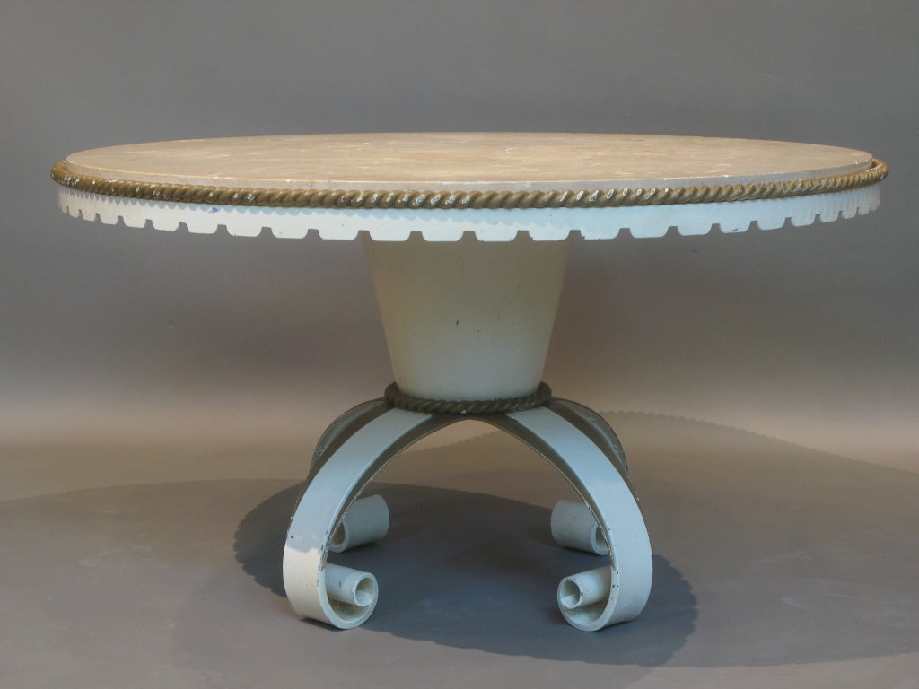 Round cocktail or coffee table by Roger Merceris from the 1940s. Conical shaped base on four scrolling feet. Wrought iron rope detailing around the top and the base and a crenellated apron.<br />
<br />
Top made of a thick slab of beige marble.<br