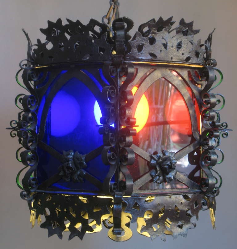 Large and decorative hexagonal lantern with a wrought-iron structure and panes of coloured glass (red, blue & green).