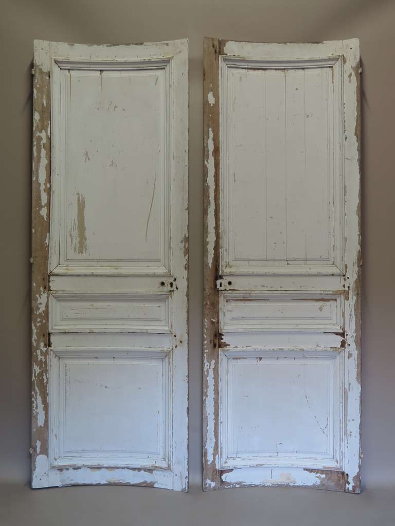 An elegant pair of curved doors made of oak. The paint is original and worn. Could be re-painted.