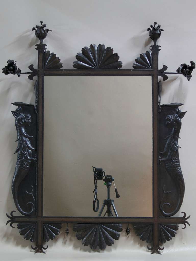 Decorative mirror in a wrought-ion frame decorated with 