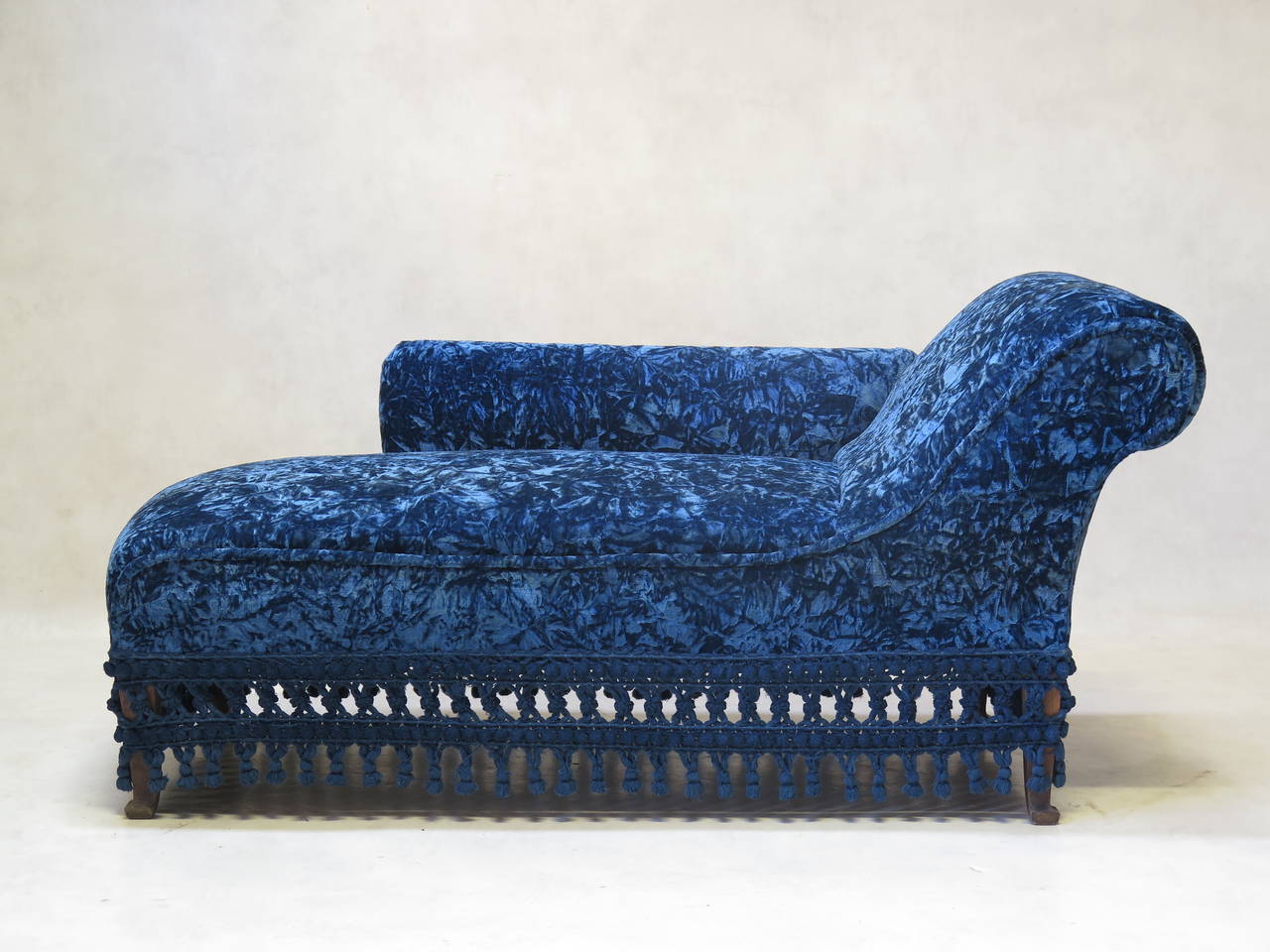 Nice Napoleon III period chaise longue, with a rolled back. Newly upholstered in vintage dark peacock-blue crushed velvet, with wide fringe around the bottom.