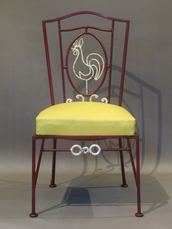 Quirky and charming set comprising 2 tables and 4 chairs.

The structure is made of hand-wrought iron painted a deep red with detailing picked out in white. 

The chair backs represent a cockerel. The seats are upholstered in yellow and orange