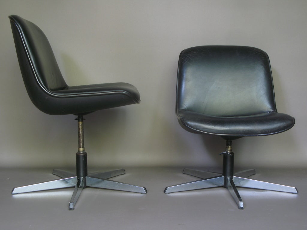 Black plastic shell, with the seat and back upholstered in black leather.

Lever to adjust height.

Chromed base.

Dimensions provided below are measured with the seats set to their lowest height. At their highest, they measure:

Height: 91