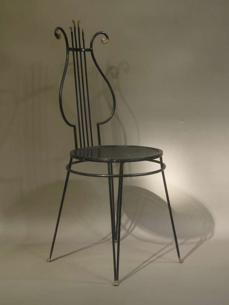 Charmante chaise d'appoint, avec dossier en forme de lyre. Peint en noir, avec des pointes dorées (dessus et pieds). Siège en métal perforé. 

Très décoratif.