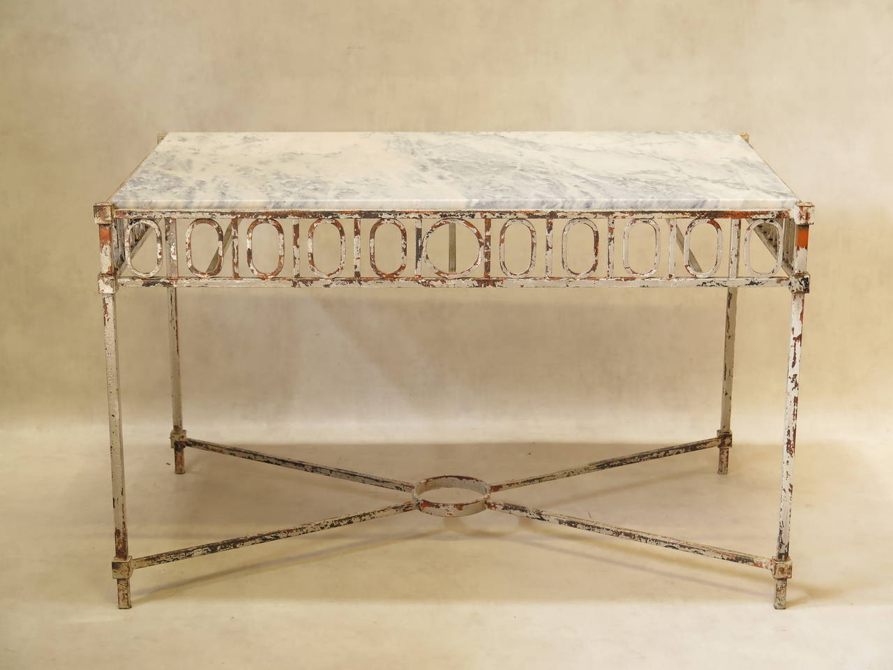 Elegant and timeless neoclassical-style Art Deco wrought iron console table, with a white marble top veined with grey. The graphic, Louis XVI inspired motif on the apron runs around three sides of the table (front and sides). Heavily worn white