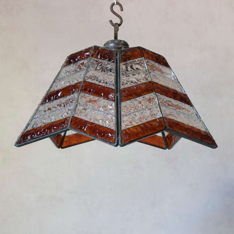 Wonderful five-sided hanging light by Italian firm Poliarte, made of rough-cut glass (clear and deep orange) in a gilt metal structure.

Very heavy and well-made.