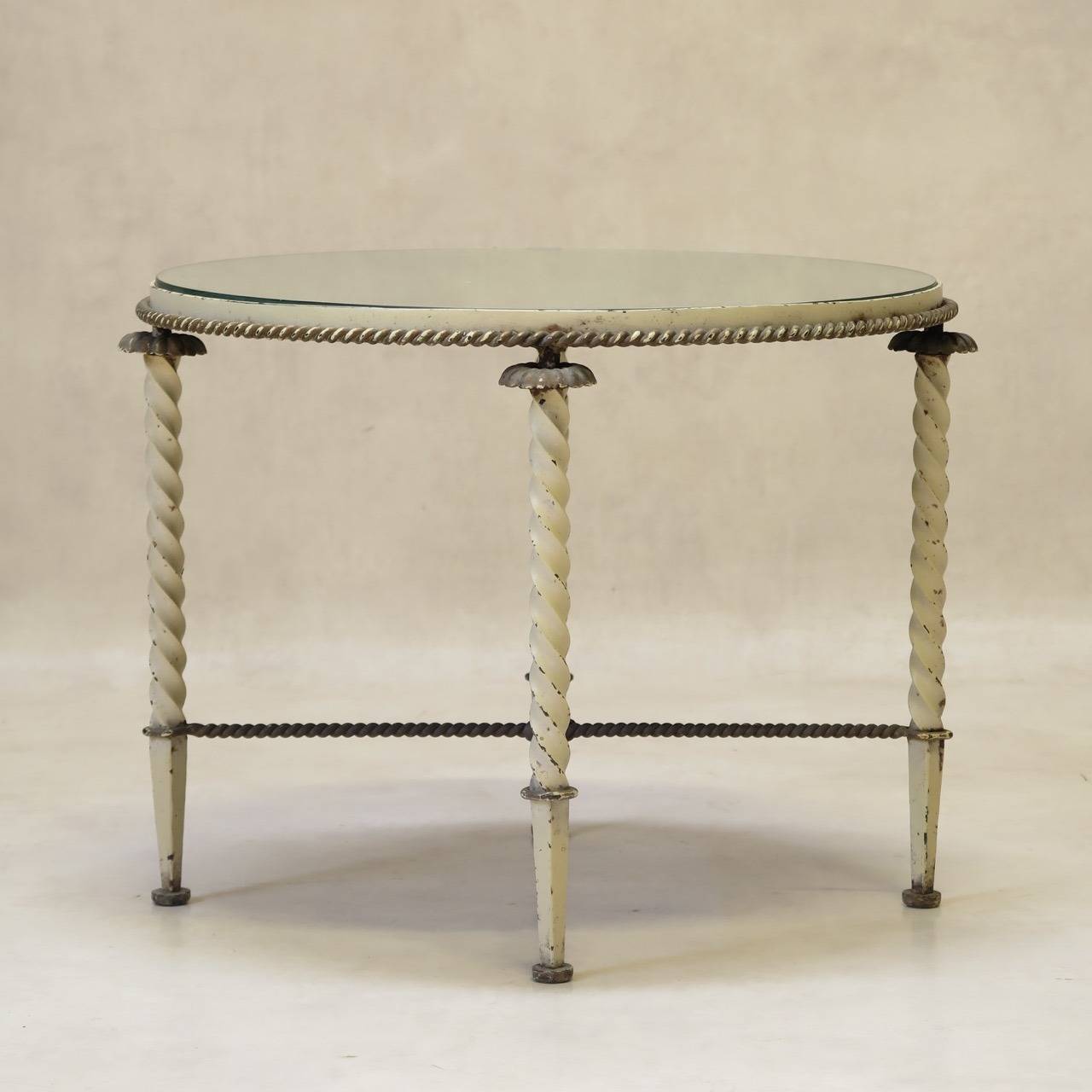 Wrought iron side table attributed to Gilbert Poillerat, raised on four twisted iron legs with iron rosette detail. X-shaped wrought iron rope stretcher. Twisted rope detail equally around the base of the apron. Painted off-white, with gilt accents.