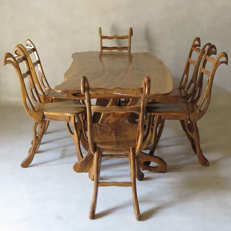 Wonderful dining-room set of unique design, comprising a rectangular table and six chairs, entirely carved out of solid olive wood (a warm-coloured and very dense hard wood, with lovely markings).

The table has a free-form top and inverted