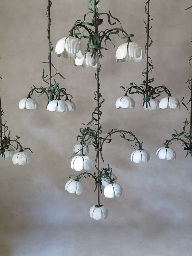 Lovely and very decorative set of six painted tôle pendants/chandeliers of varying size, representing stylised lily of the valley.

Orirginal white, green and brown paint. Very long and elegant stems.

Two long chandeliers, three slightly